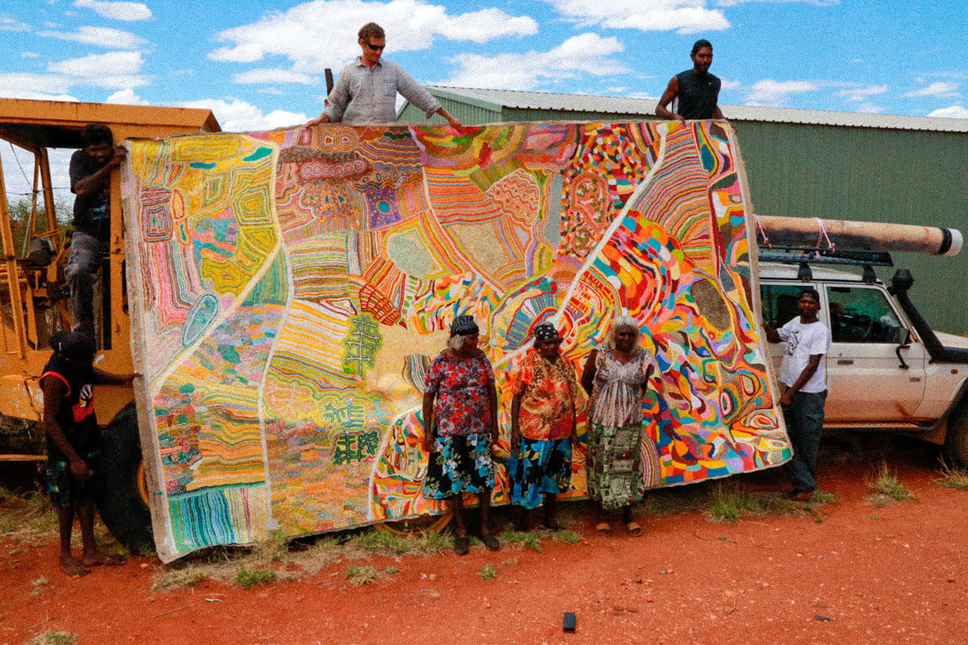 The artists in front of the key visual, a hugely scaled map of the Australian continent 