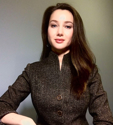 Anna Medvedovska: sie trägt langes braunes Haar über die Schulter fallend, blaue Augen und ein feines Gesicht.
