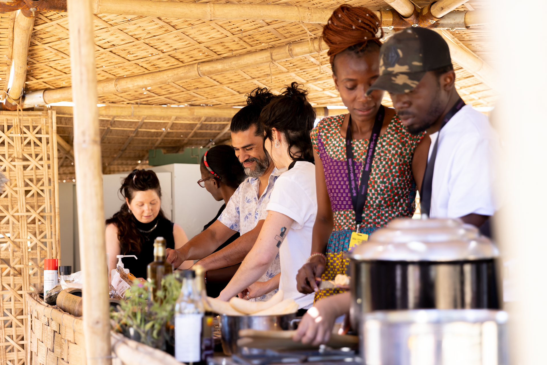 Suppenküche während der documenta 15: Sechs Menschen unterschiedlicher Herkunft bereiten das Essen zu.Soup kitchen during documenta 15: six people from different backgrounds prepare the food.