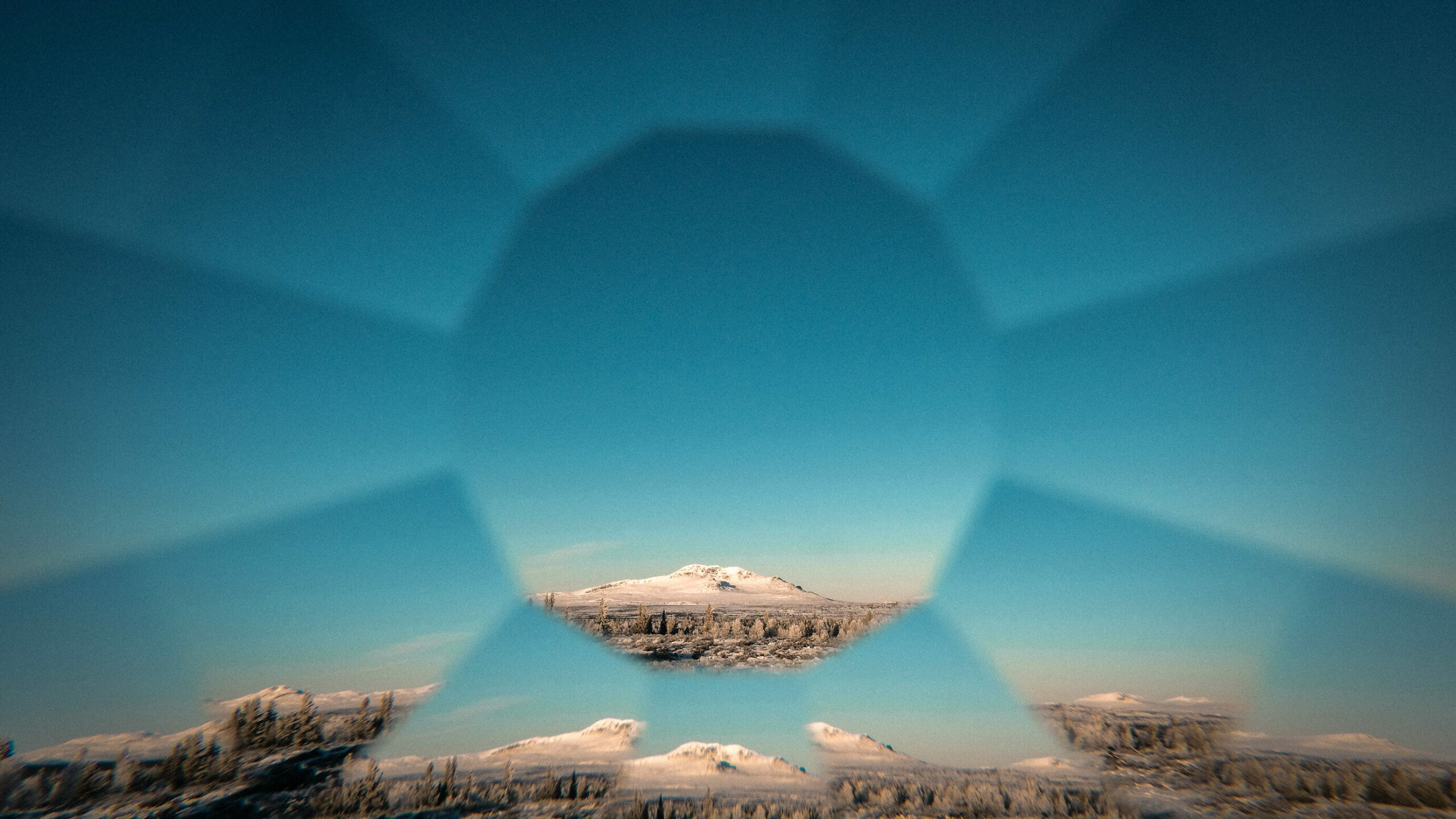 A landscape of mountains through a diamond shaped lens.