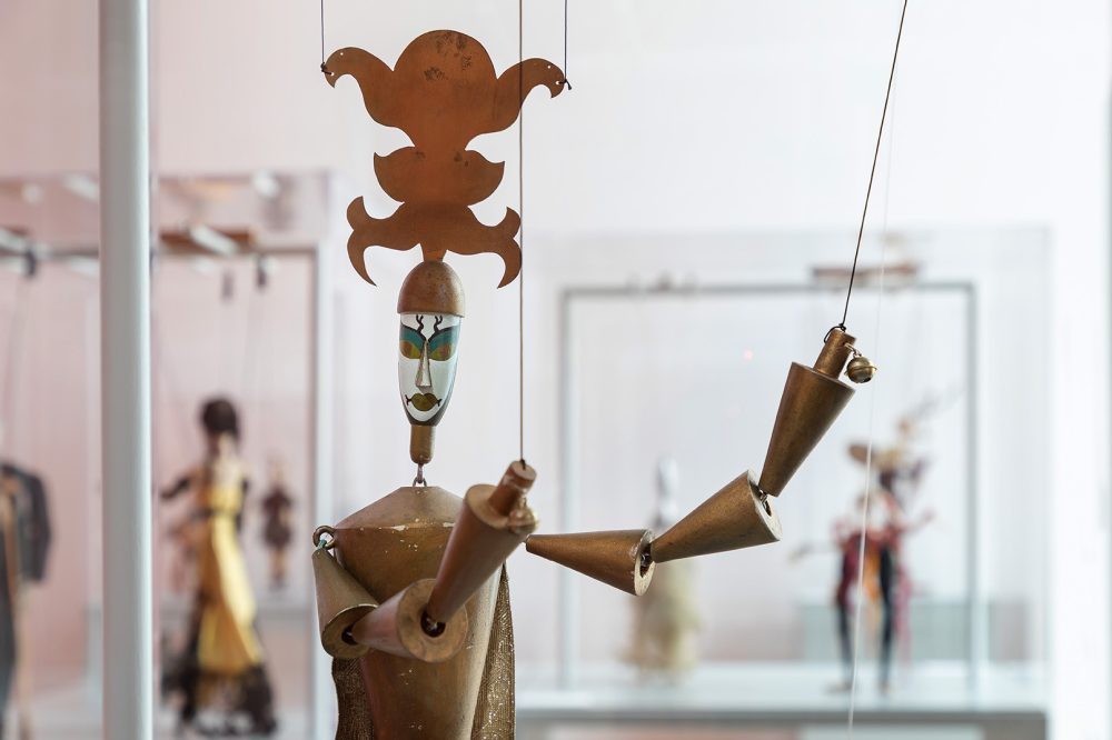 an old golden puppet, geometric shapes, white mask