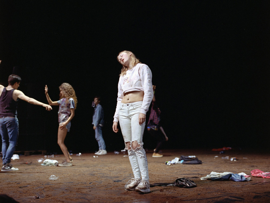 performance, a girl dressing in white standing in a messy and undefined landscape