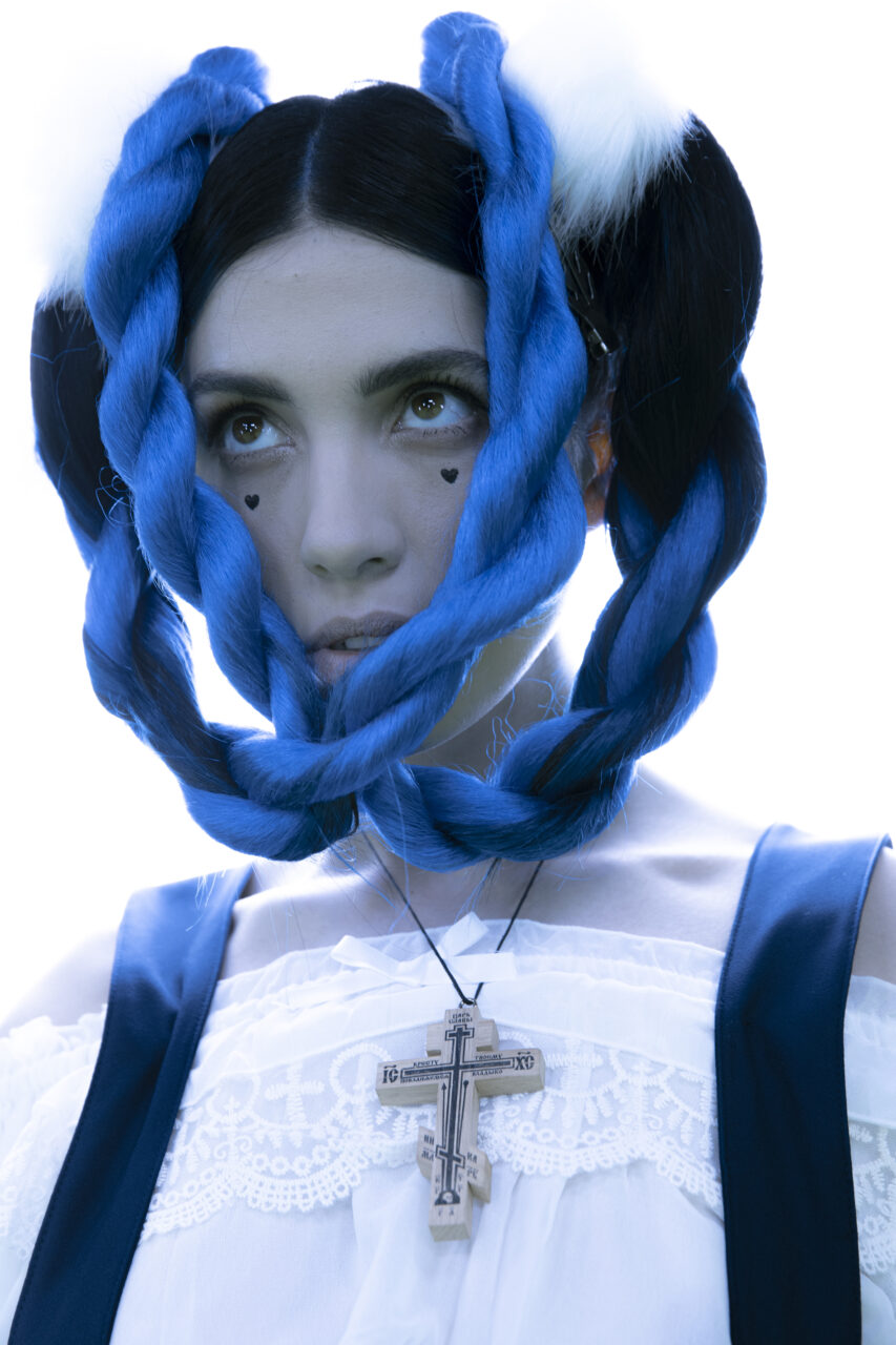 portrait of a woman, blue braids, cross on her neck